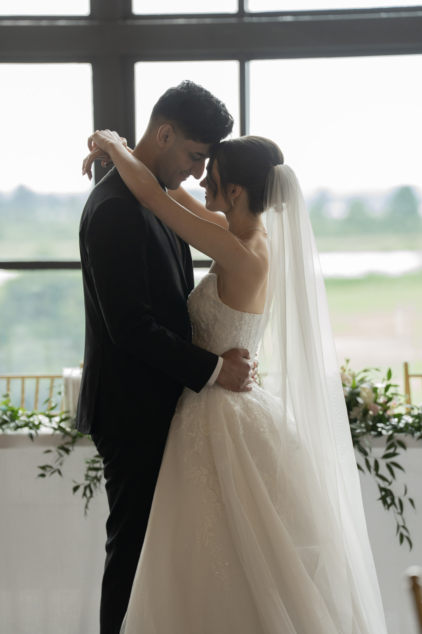 Couple embracing beside a large window